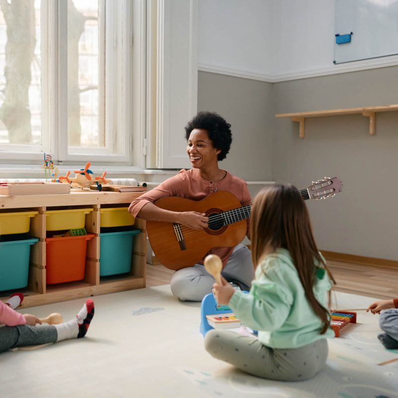 happy-black-teacher-and-group-of-kids-enjoying-during-music-class-at-kindergarten-.jpg